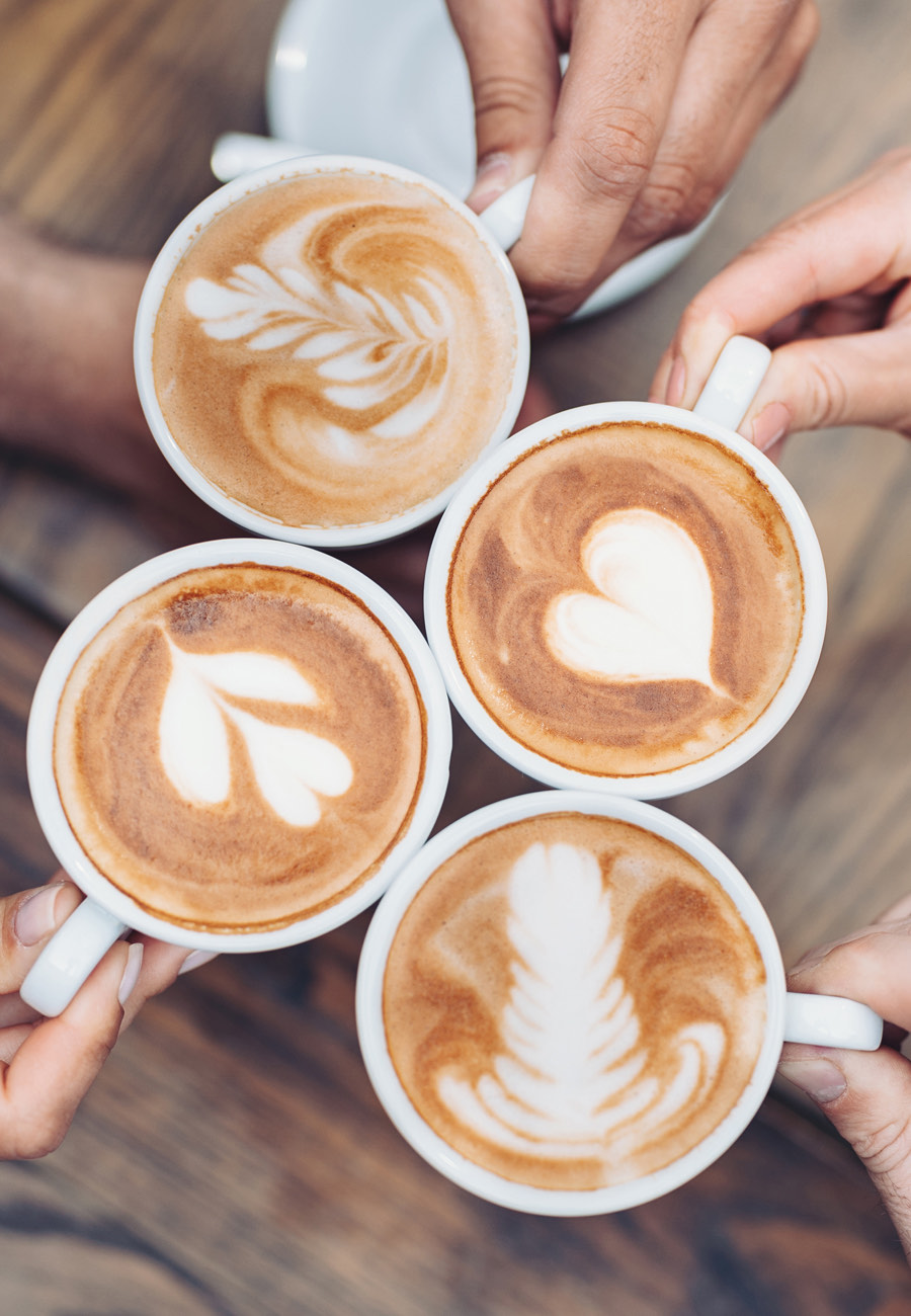 Vier collega&rsquo;s met koffietassen tijdens een gedeeld koffiemoment